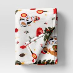 a white blanket with red and green animals on it