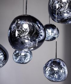 several glass balls hanging from the ceiling in a room with white walls and flooring