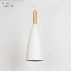 a white light hanging from a ceiling with a wooden stick sticking out of it's end