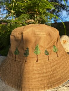 a brown hat with trees on it sitting next to some rocks and green plants in the background