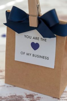 a brown paper bag with a blue heart on it that says, you are the love of my business