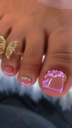 a woman's toe with pink and gold designs on it