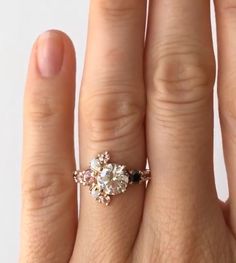 a woman's hand with an engagement ring on top of her finger, showing the center stone