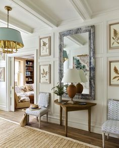 a living room filled with furniture and a large mirror on the wall next to a table