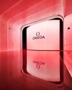 the interior of a building with red lighting and signs on the wall that read omega