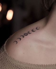 a woman with a tattoo on her chest that has phases of the moon in it