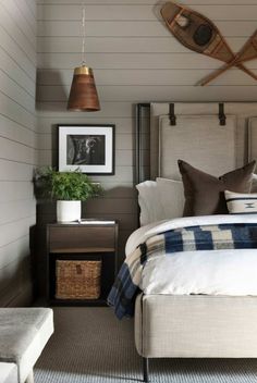 a bed room with a neatly made bed next to a night stand and two pictures on the wall