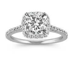 an engagement ring with a cushion cut diamond surrounded by pave diamonds