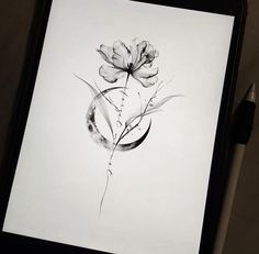 a black and white photo of a flower on a sheet of paper next to a pen