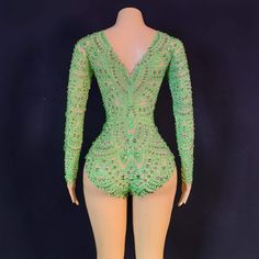 a mannequin wearing a green bodysuit with sequins