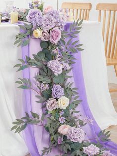 the table is decorated with purple flowers and greenery