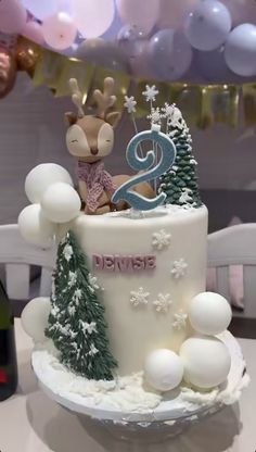 a birthday cake decorated with white frosting and christmas decorations, including a reindeer figure