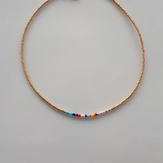 a gold beaded bracelet with multicolored beads