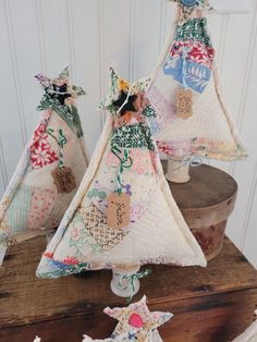 three small christmas trees on top of a wooden table next to other ornaments and decorations