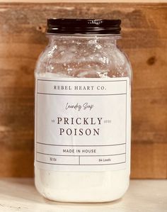 a jar filled with lots of white stuff sitting on top of a wooden shelf