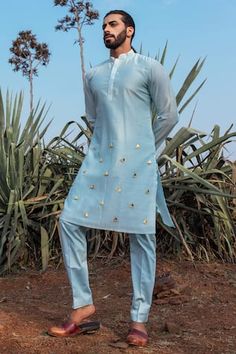 Powder blue hand dyed chanderi silk kurta with pleated mandarin collar and gold boat motifs metallic trims embroidery. Paired with pant pyjama.
Components: 2
Pattern: Hand Embroidered
Type Of Work: Metallic Trims Work
Neckline: Mandarin Collar
Sleeve Type: Full Sleeves
Fabric: Kurta: Chanderi Silk, Pyjama: Vegan Silk
Color: Blue
Other Details: 
Hand dyed
Side slits
Kurta Closure: Front button placket
Disclaimer: The fabrics used, are handwoven, hence may have impurities or slubs/variation in the Blue Indian Outfit, Silk Kurtas, Organza Kurta, Wedding Kurta For Men, Sea Blue Color, Indian Groom Wear, Gents Kurta Design, Men Fashion Photo, Gents Kurta