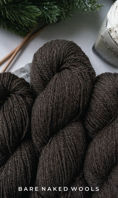 two skeins of yarn next to some needles