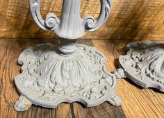 an old cast iron candle holder on a wooden table with two other candlesticks