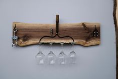 three wine glasses are hanging on a wooden rack with four wine glasses attached to it