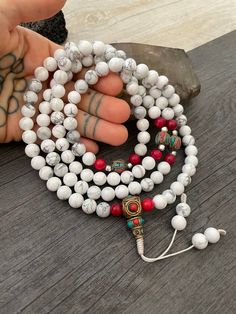 Beautiful Howlite Mala from Nepal and Mountain shell beads Mala necklace. You can choose between the mala that is made with howlite beads (white with gray) and mix metal beads from Nepal, or the all white mala necklace, which is made with mountain shell beads and a yellow mantra symbol. A unique praying mala that can be used as a necklace or as an ornament. The mala has no clasp, you wear it over the head. --The Mala with the metal beads and the red beads has a total length of 48.2cm- 19 inch lo White 108 Beads Jewelry As A Gift, White Beaded Bracelets With 108 Beads For Meditation, White Mala With 108 Beads For Healing, White Healing Mala With 108 Beads, White Adjustable Mala With Gemstone Beads, Adjustable White Mala With Gemstone Beads, White Spiritual Mala With 8mm Beads, Adjustable White Mala With 8mm Beads, Adjustable White Gemstone Beads Mala