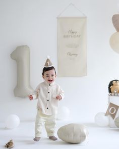 a little boy standing in front of balloons