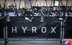 there is a sign that says hyrox in front of some chairs and tables