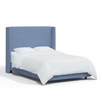 a bed with a blue headboard and white sheets on it's sides, against a white background