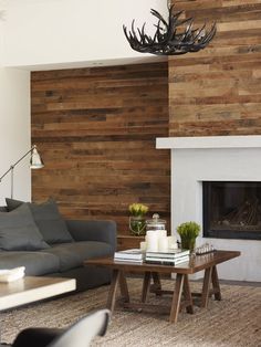 a living room with wood paneling on the walls and furniture in front of it