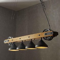 an industrial style light fixture with three lights hanging from it's sides and two black lamps on the other side