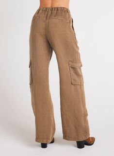 Introducing our latest addition, Jules Pleated Wide Leg. With cargo pockets and pleated detailing. Whether you're going for a casual or a more polished look, this cargo pant is the perfect choice for any occasion. 55% Linen 45% TENCEL™ Lyocell. SIZE WAIST WAIST TO HEM RISE INSEAM XS 26 1/2" 43" 11 7/8" 31 1/2" S 28 1/2" 43 1/2" 12 1/2" 31 1/2" M 30 1/2" 44" 13 1/8" 31 1/2" L 32 1/2" 44 1/2" 13 3/4" 31 1/2" Casual Linen Pants With Multiple Pockets, Brown Utility Cargo Pants With Flap Pockets, Utility Linen Cargo Pants With Cargo Pockets, Casual Brown Pants With Flap Pockets, Utility Linen Cargo Pants With Relaxed Fit, Baggy Khaki Cargo Jeans For Workwear, Linen Utility Bottoms With Side Pockets, Utility Wide Leg Linen Bottoms, Utility Linen Bottoms With Side Pockets