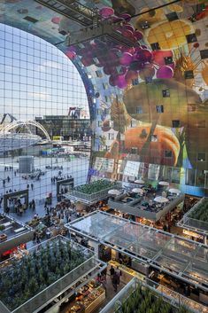 the interior of a shopping mall with many people walking around and looking at their surroundings