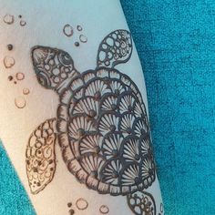 a close up of a person's arm with a tattoo on it and an image of a turtle