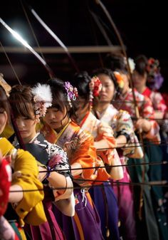 a group of young women dressed in traditional japanese garb standing next to each other