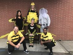 some people are dressed in costumes and posing for a photo with one person wearing a bee costume