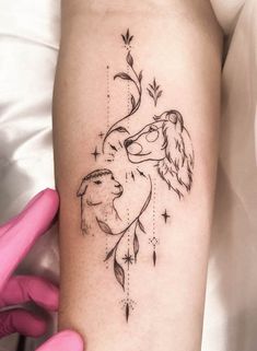 a woman's arm with a tattoo on it that has an image of two lions