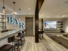 a bar with stools in front of it and a television on the wall behind it