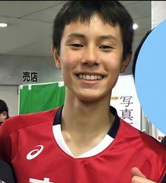 a young man holding up a blue frisbee