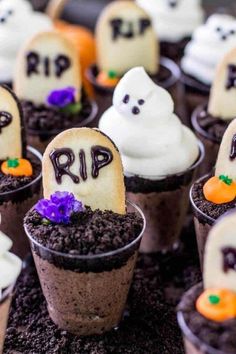 halloween cupcakes with ghost faces and tombstones on them are sitting in dirt