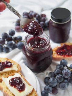 someone is dipping jam on bread with blueberries