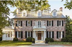 a large brick house with black shutters and white trim