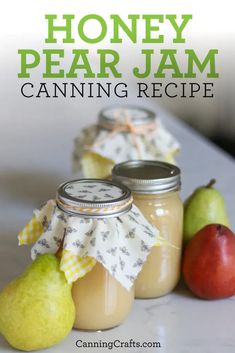 three jars filled with honey, pear jam and two pears on a counter top