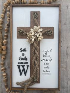 a cross with flowers on it is hanging in front of a string and wood bead