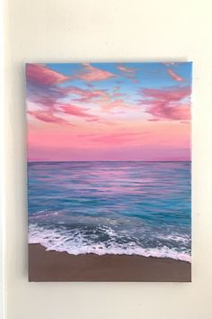 a painting on the wall of a beach with waves coming in to shore at sunset