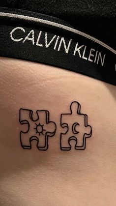 a person with a tattoo on their stomach that has two pieces missing from the same puzzle piece