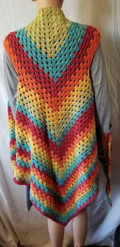 a mannequin wearing a multicolored crocheted sweater