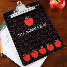 a clipboard with an apple on it next to some pencils and an apple