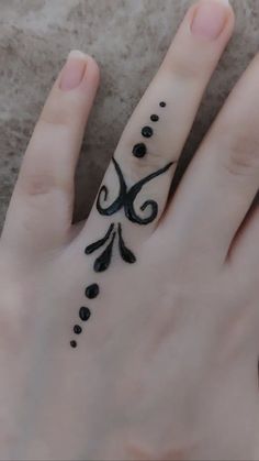 a woman's hand with a tattoo design on the thumb and ring finger area