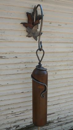 a rusted fire extinguisher hanging from a hook on the side of a building