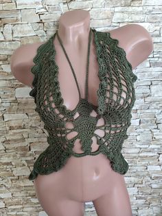 a female mannequin wearing a green crochet halter top and necklace