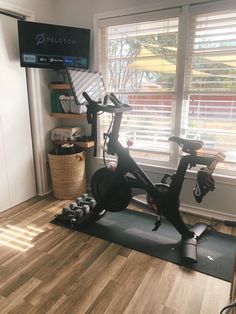 there is a stationary bike in the corner of this home gym room, with no one around it